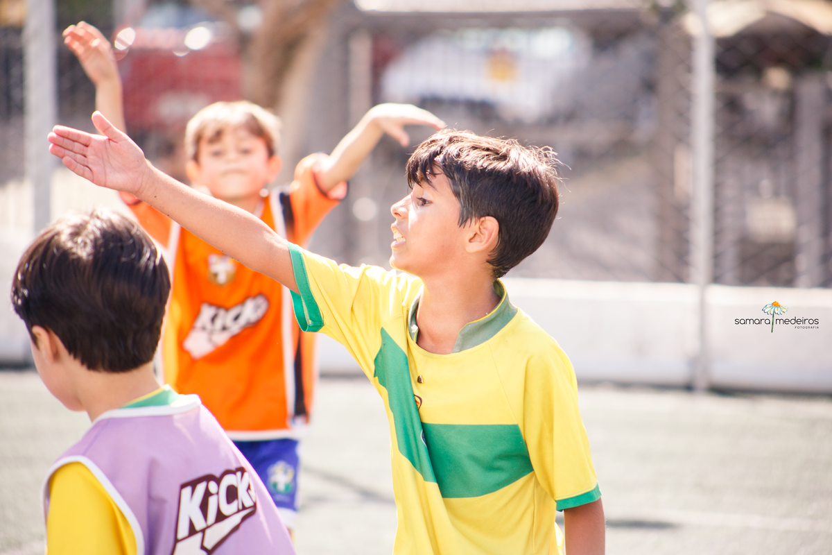 Criança discutindo e apontando durante um jogo de futebol.