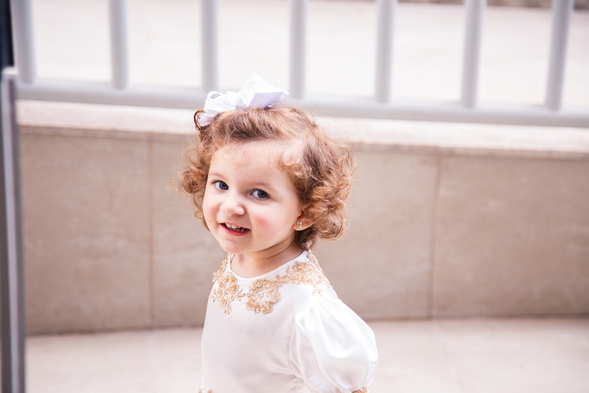 Criança olhando para câmera e sorrindo enquanto anda.