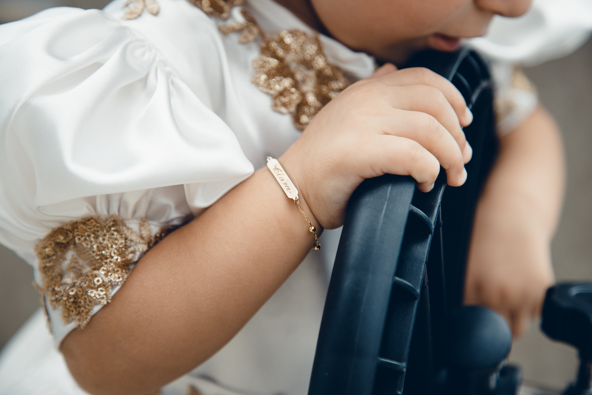 Close na pulseira de uma criança que está brincando com um volante em sua festa de aniversário.