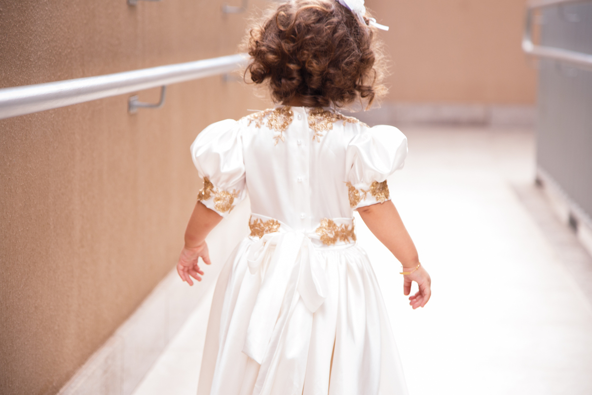 Criança de costas descendo uma rampa da área da piscina durante sua festa de aniversário.