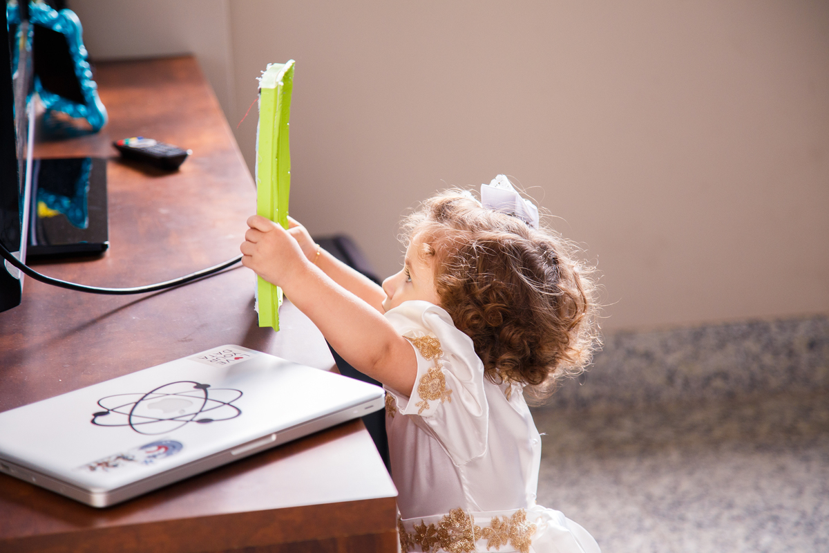 Criança com um porta retratos na mão olhando para a foto.