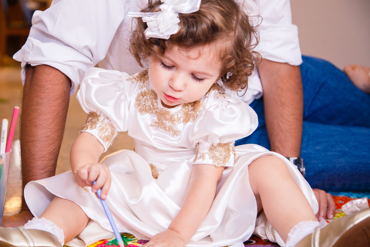 Close na criança sentada no chão brincando de desenhar.