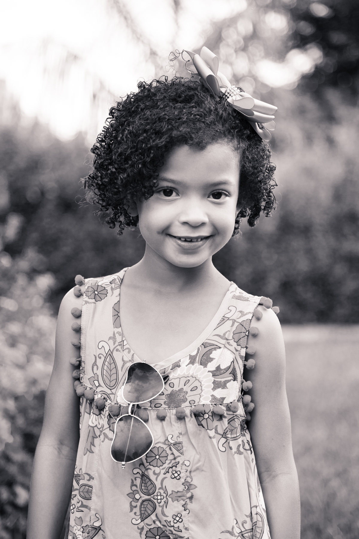 Foto em preto e branca de uma criança posando para foto em um parque de Belo Horizonte.