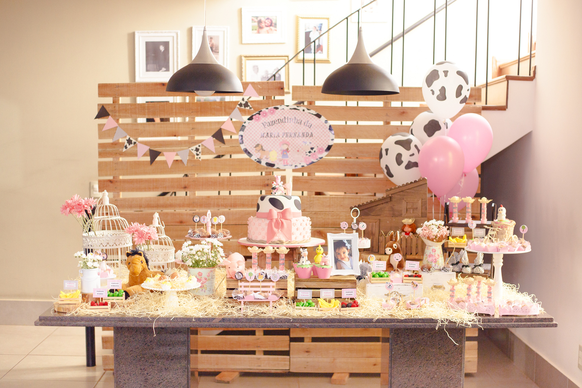 Mesa do bolo de um aniversário infantil com o tema fazendinha.