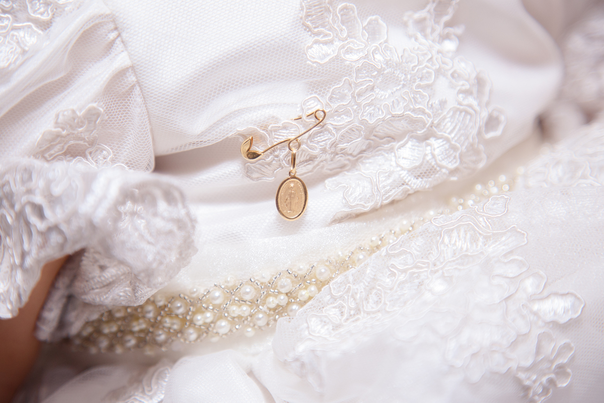 Detalhe do vestido da bebê que está completando um ano e do broche que usa no vestidinho.