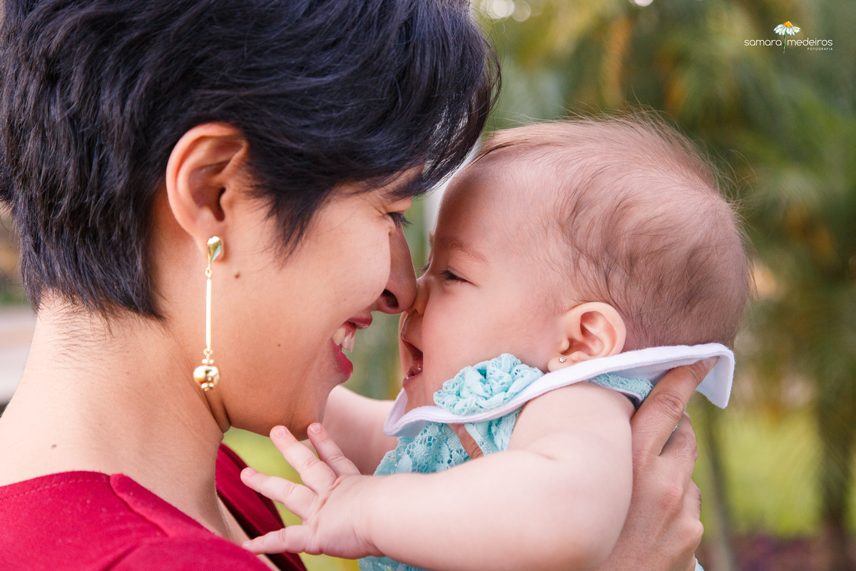 Mãe com a bebê brincando, narizes se tocando e ambas sorrindo, em Belo Horizonte.