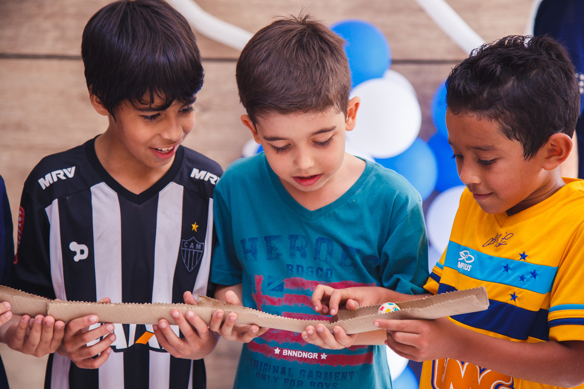 Crianças brincando de passar uma bolinha de um para o outro em um 