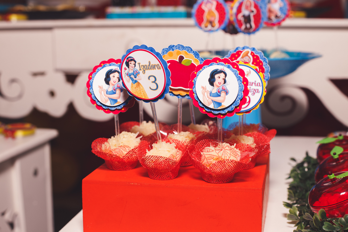 Detalhe da mesa do bolo de um aniversário infantil, com doces e personalizados.