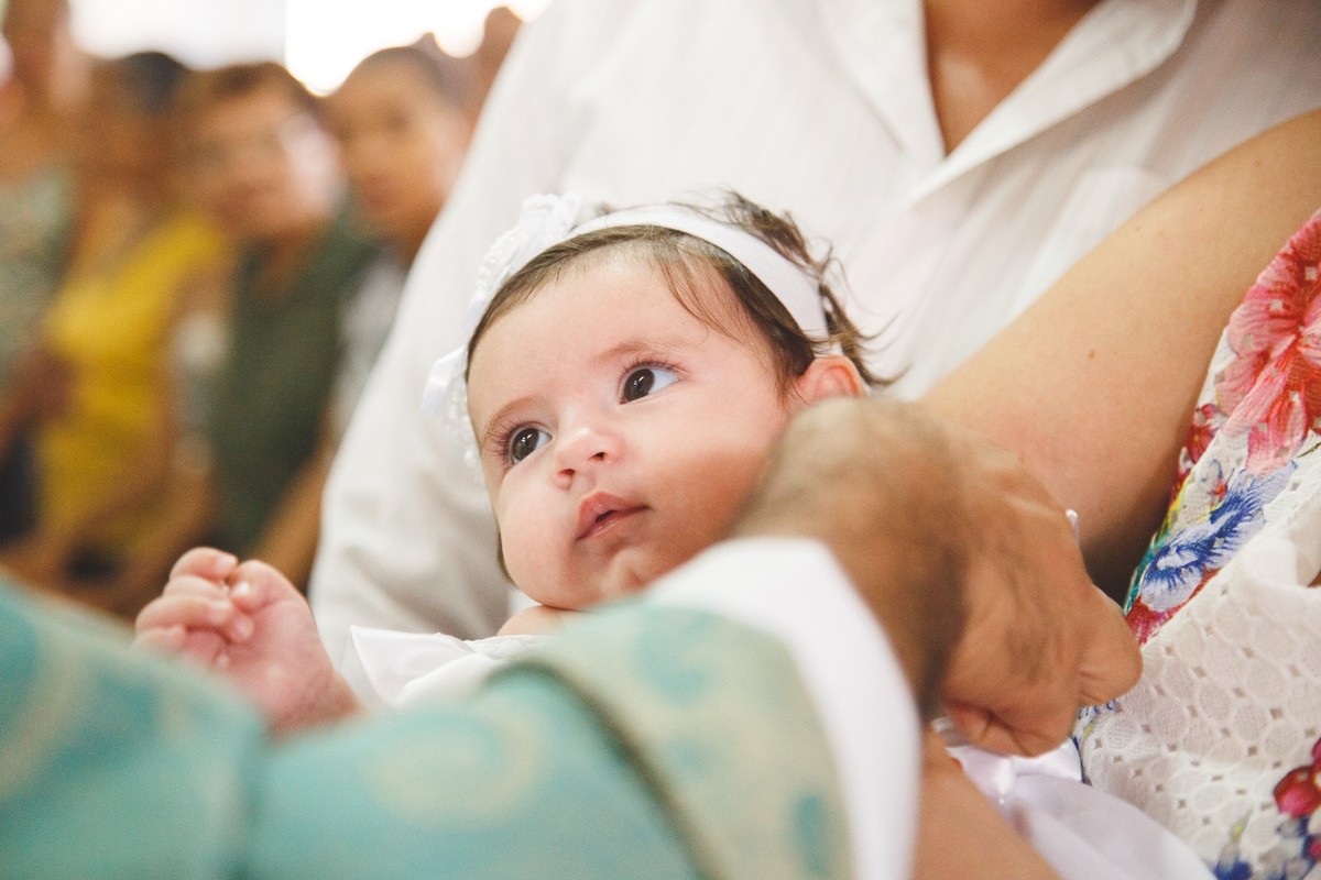 Bebê recebendo a benção com óleo ungido durante a cerimônia de seu batizado.
