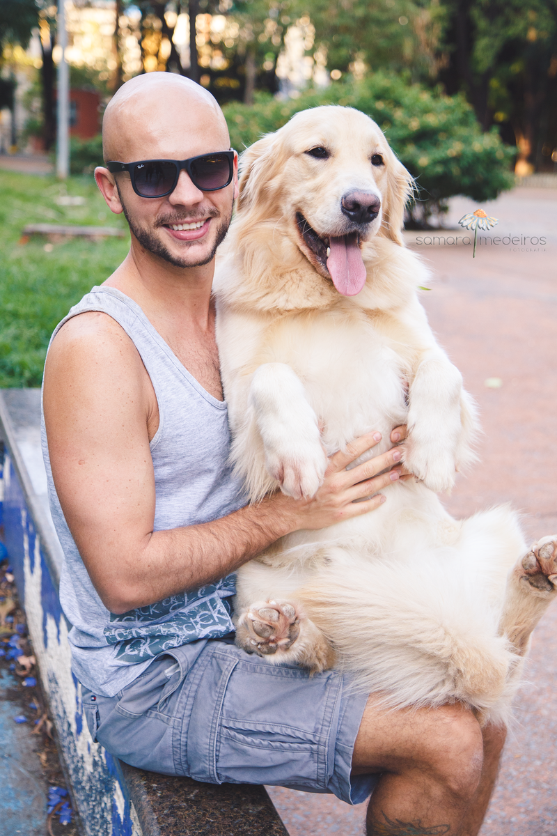 Golden sentado no colo de seu pai, ambos olhando para a foto com expressões felizes.
