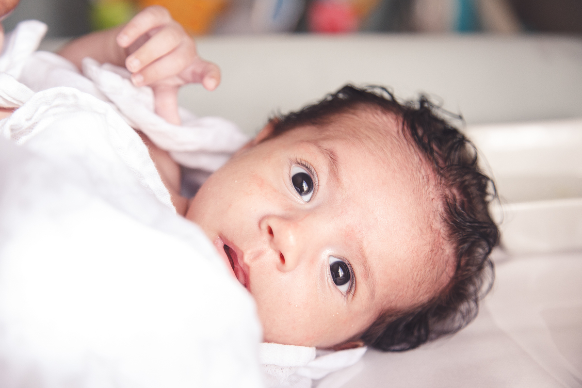 Close no rosto do bebê no trocador de roupa após tomar banho.