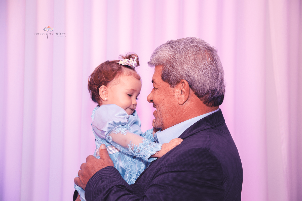 Criança de 1 ano no colo do seu avô materno em sua festa de aniversário de 1 ano.