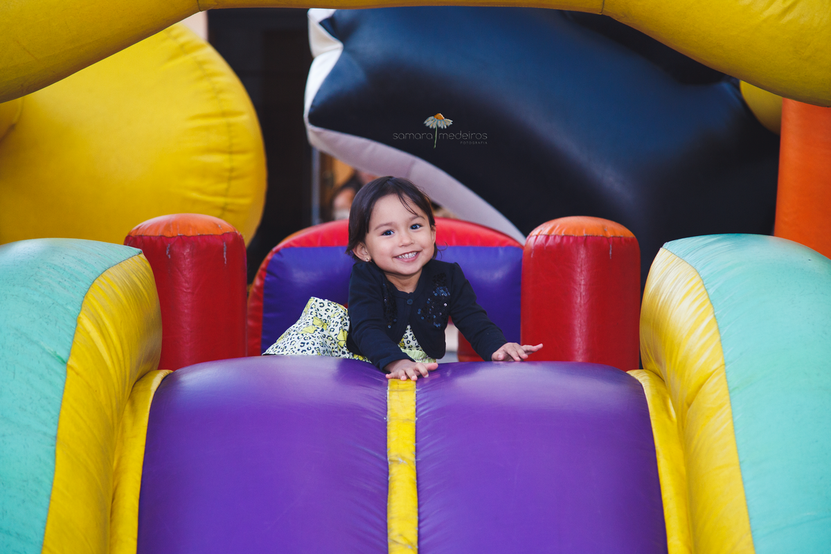 Criança de 3 anos brincando no brinquedo inflável em sua festa de aniversário.