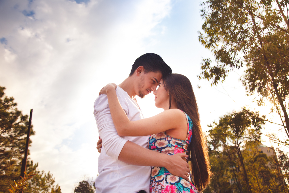 Casal abraçado, um de frente para o outro, testas se tocando e se olhando nos olhos.
