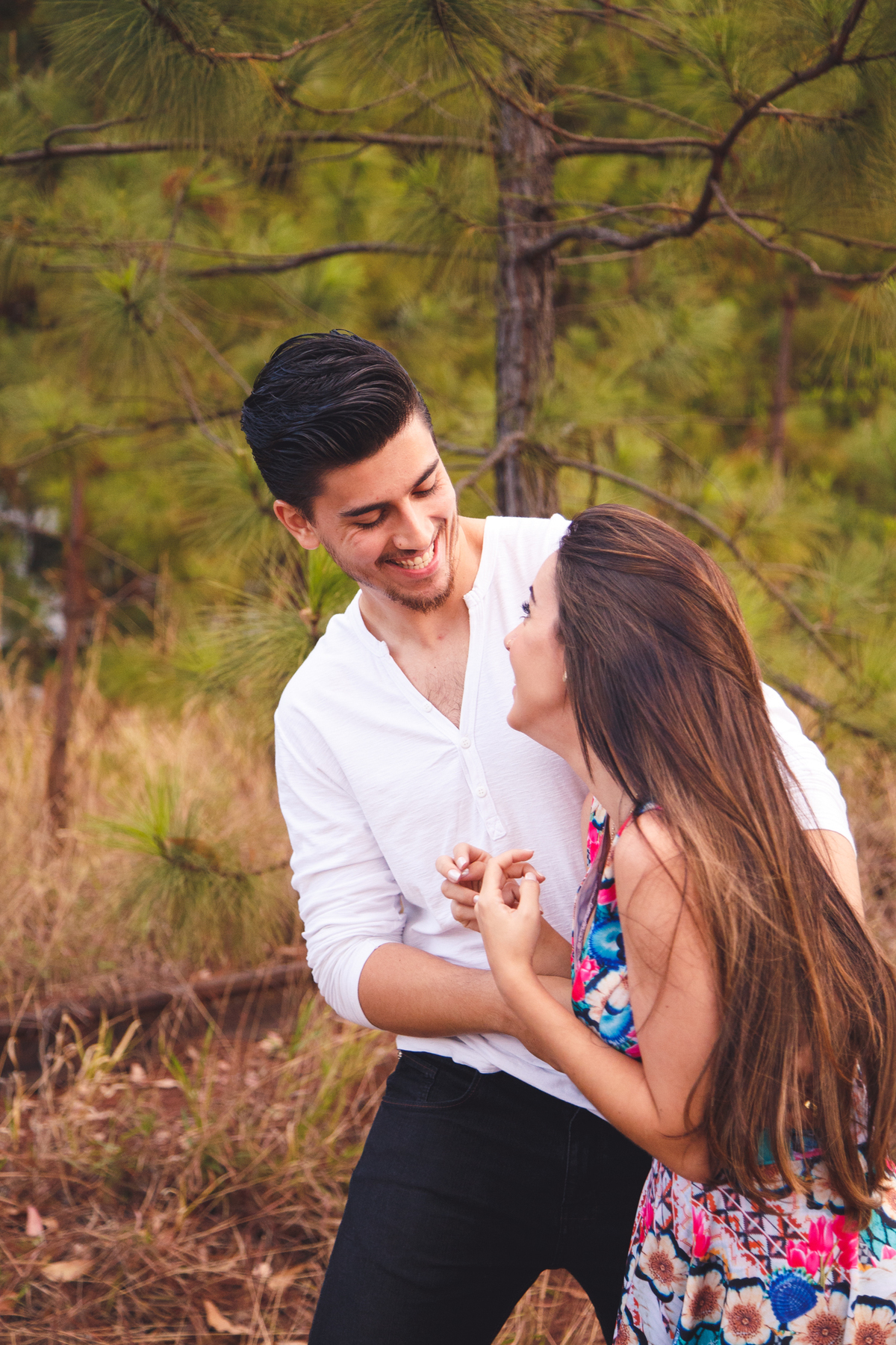 Casal brincando durante ensaio de fotos, fazendo cócegas um no outro e se divertindo.