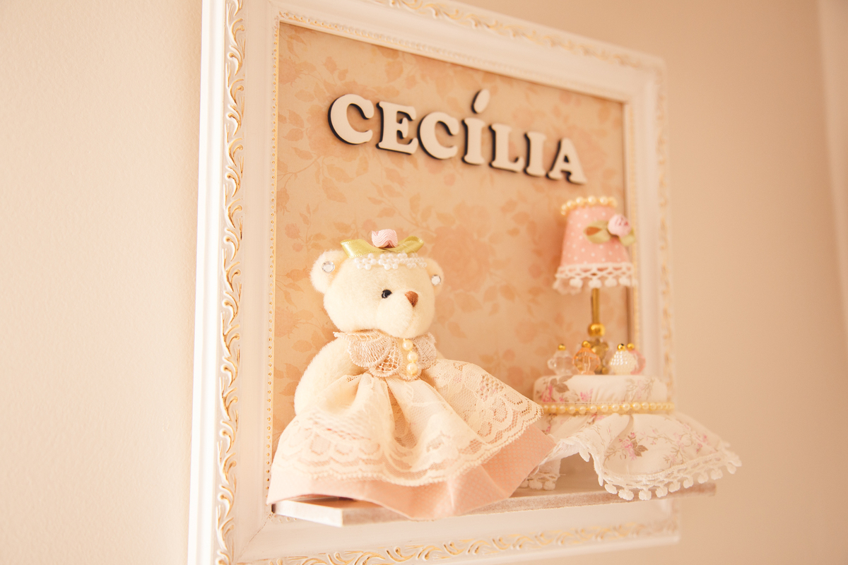 Quadrinho com nome da bebê, uma ursinha e um mini abajur que fica na porta do quarto, enfeitando.