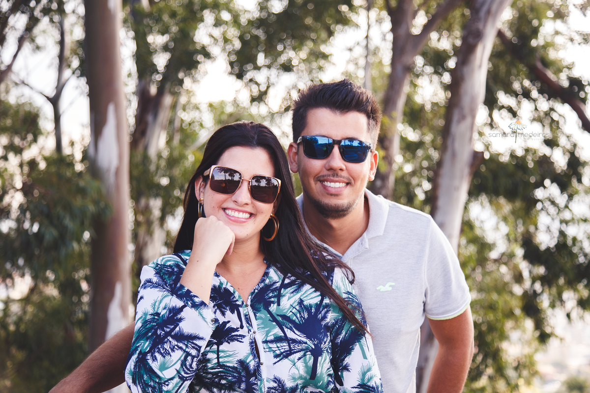 Casal de frente, olhando para a câmera e sorrindo, durante um ensaio fotográfico de casal em Belo Horizonte.
