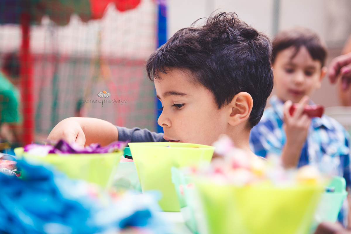Flagra de uma criança de 4 anos atacando a mesa de doces do seu aniversário.