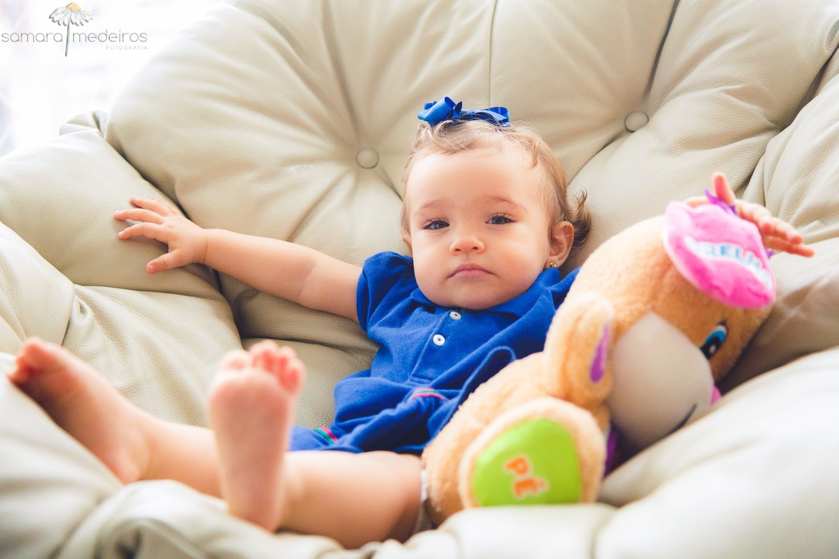 Criança sentada em uma poltrona em sua casa durante uma sessão de fotos lifestyle, em Belo Horizonte.