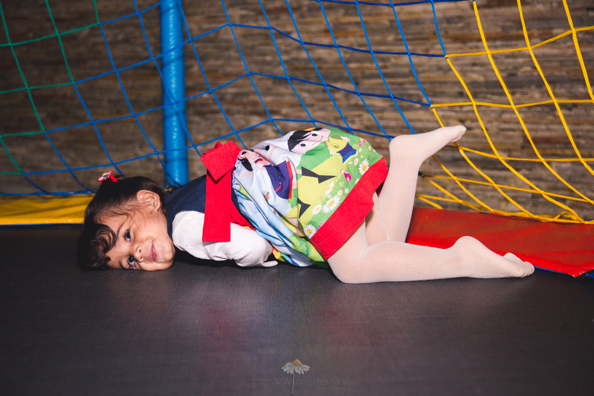 Criança brincando na cama elástica em sua festa de aniversário de 2 anos.