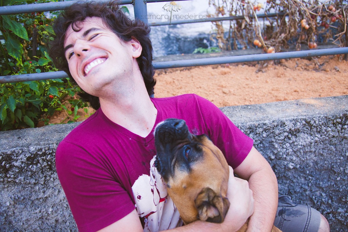 Boxer ganhando um abraço e tentando lamber o rosto de um dos membros da família, durante o ensaio fotográfico pet.