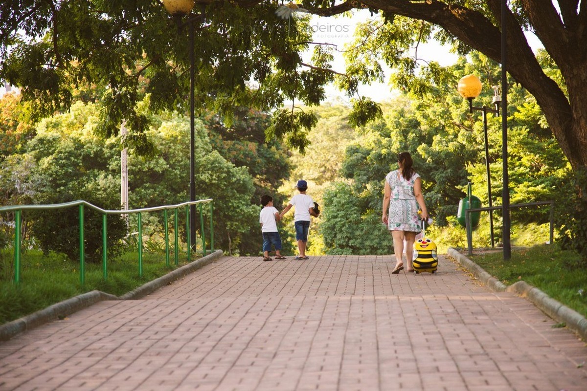 Mãe e duas crianças subindo uma rampa para chegar a um parque em Belo Horizonte.