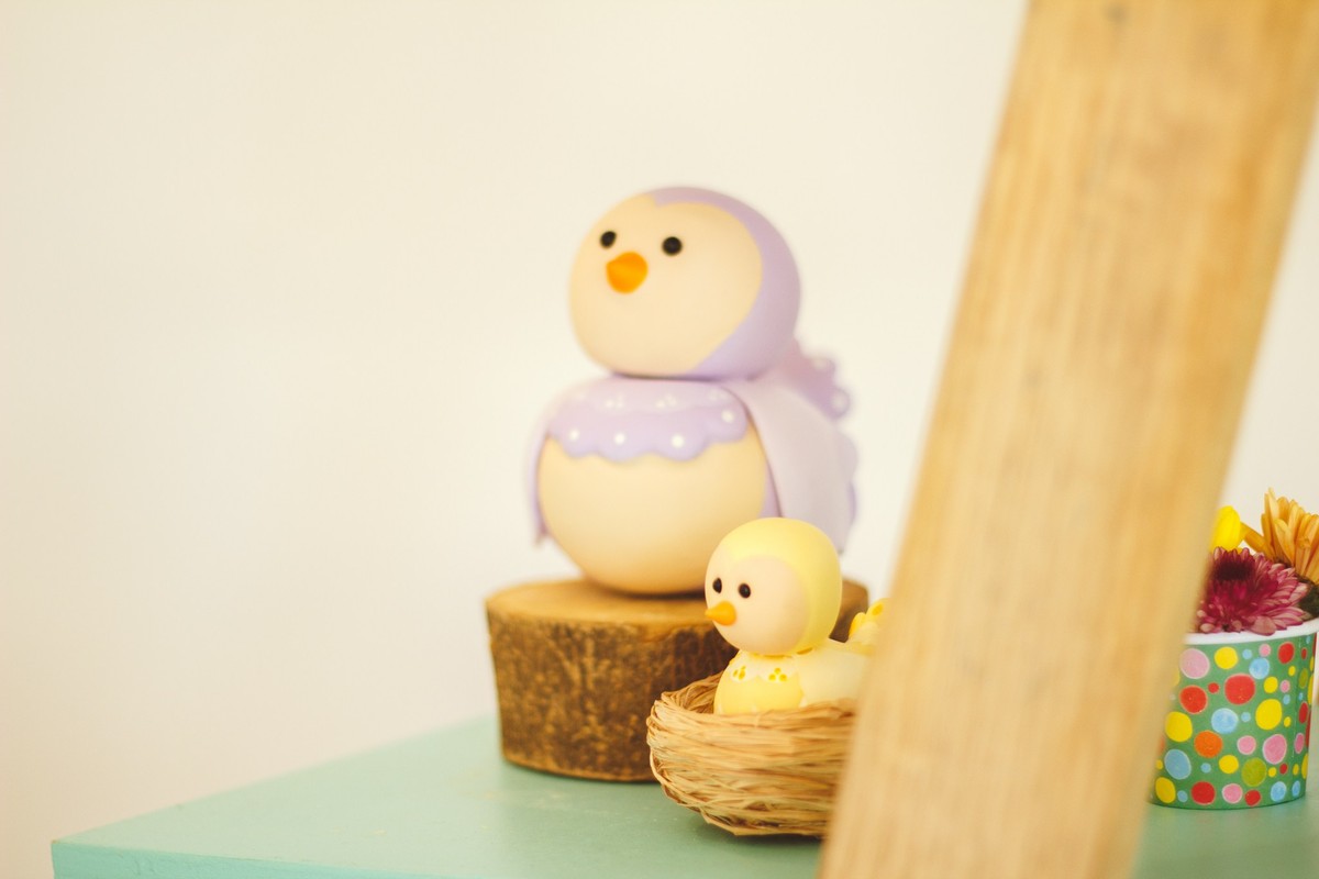 Detalhe da decoração de aniversário de 1 ano, sendo dois passarinhos de biscuit.