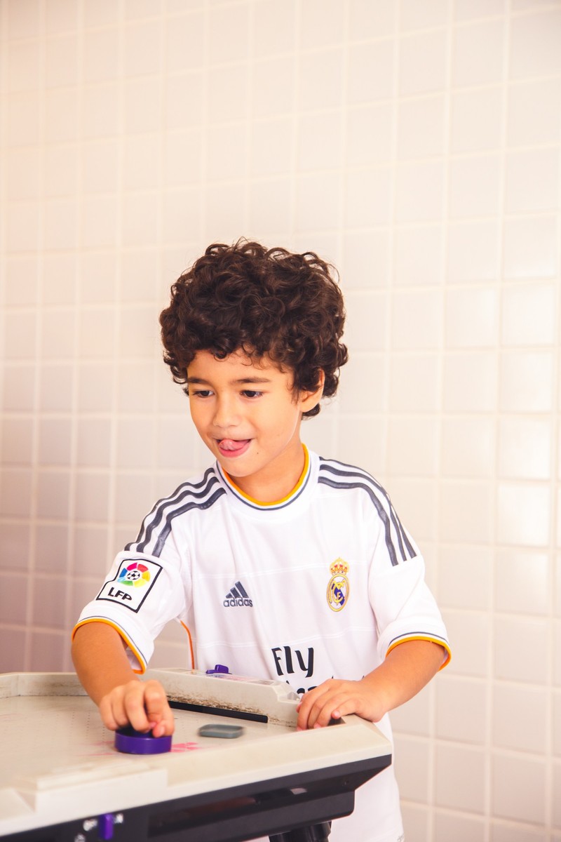 Criança fazendo careta, brincando durante um aniversário infantil.