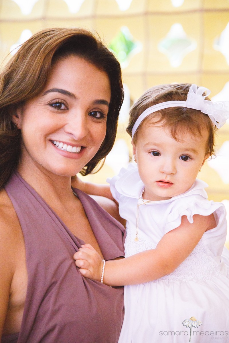 Criança e sua mãe olhando para a foto antes do batizado.