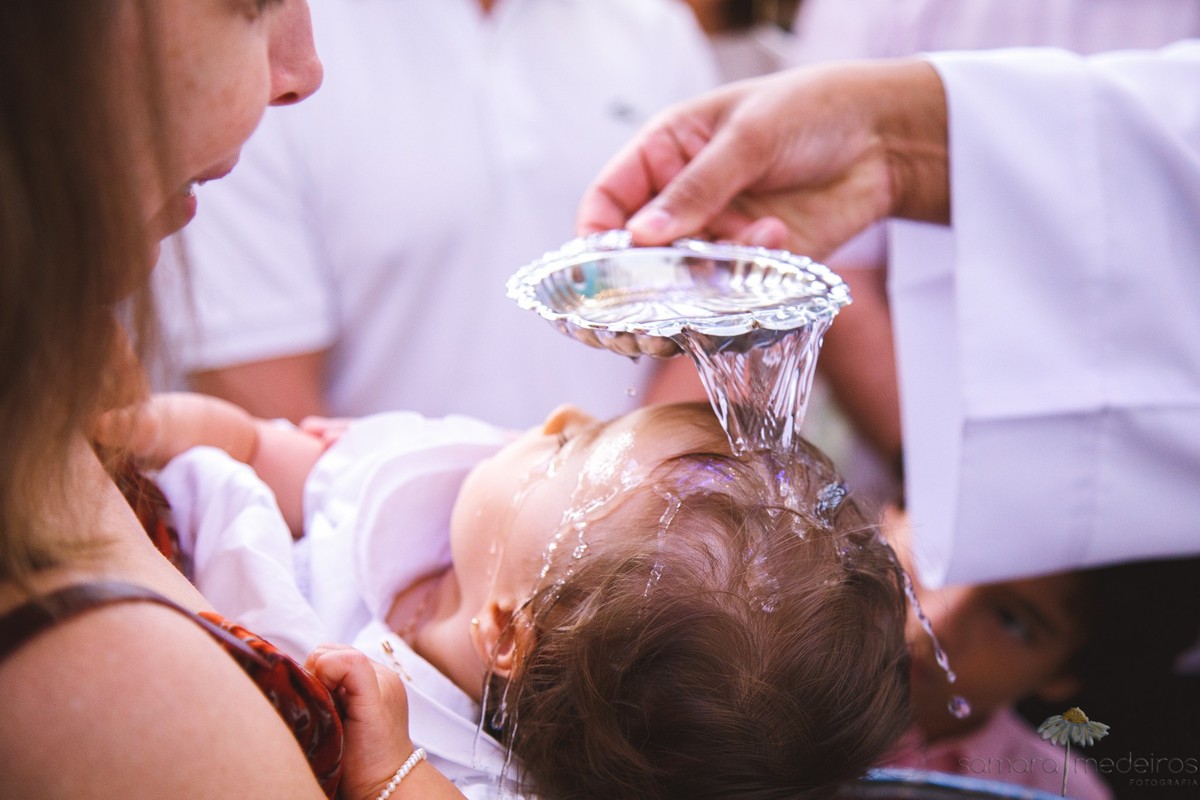 Criança sendo batizada em uma igreja católica em Belo Horizonte.
