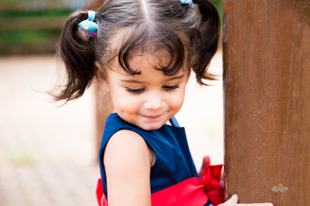 Criança brincando e posando para fotos em um ensaio fotográfico externo.