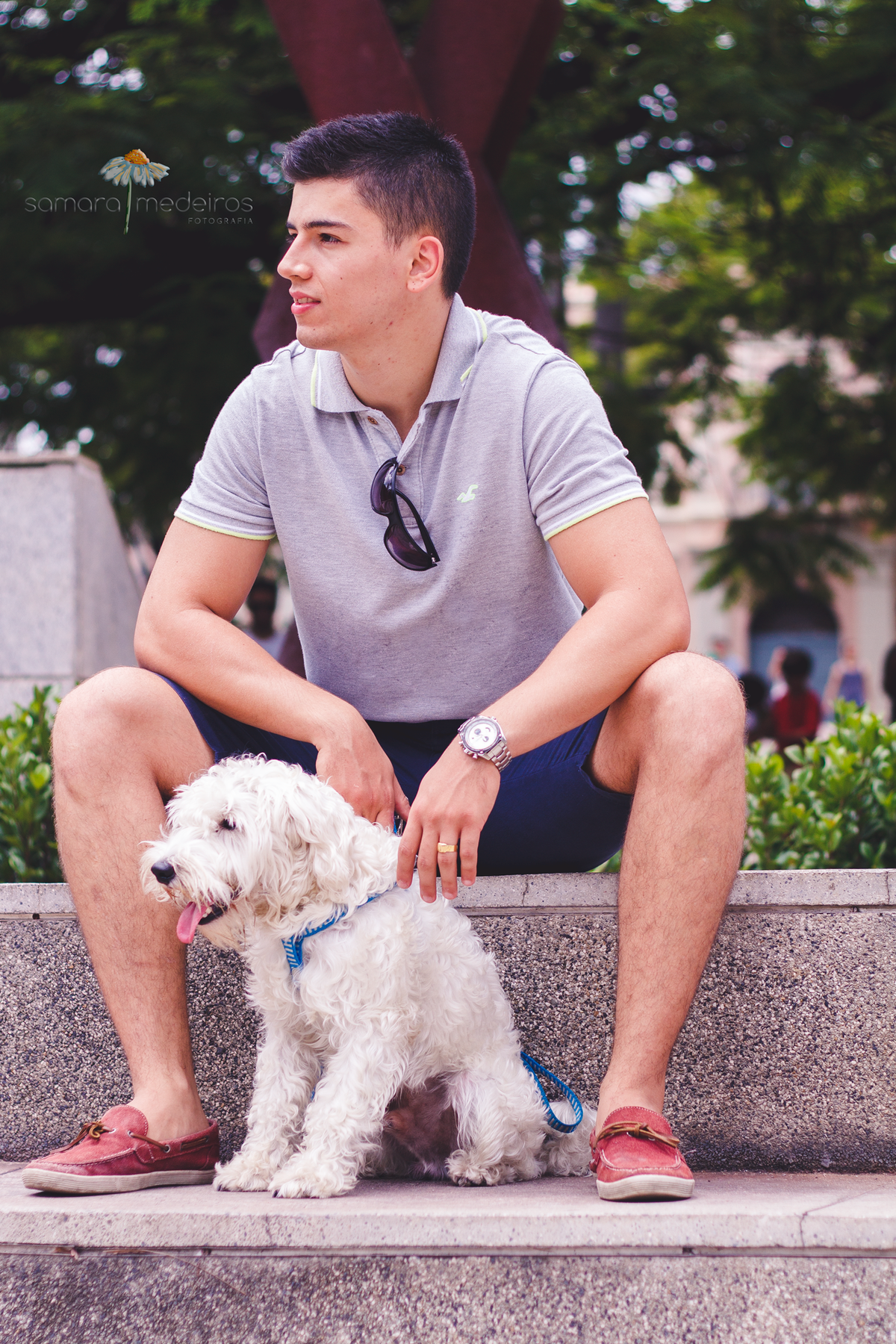 Cachorro e seu tutor sentados posando para foto em uma praça de Belo Horizonte.