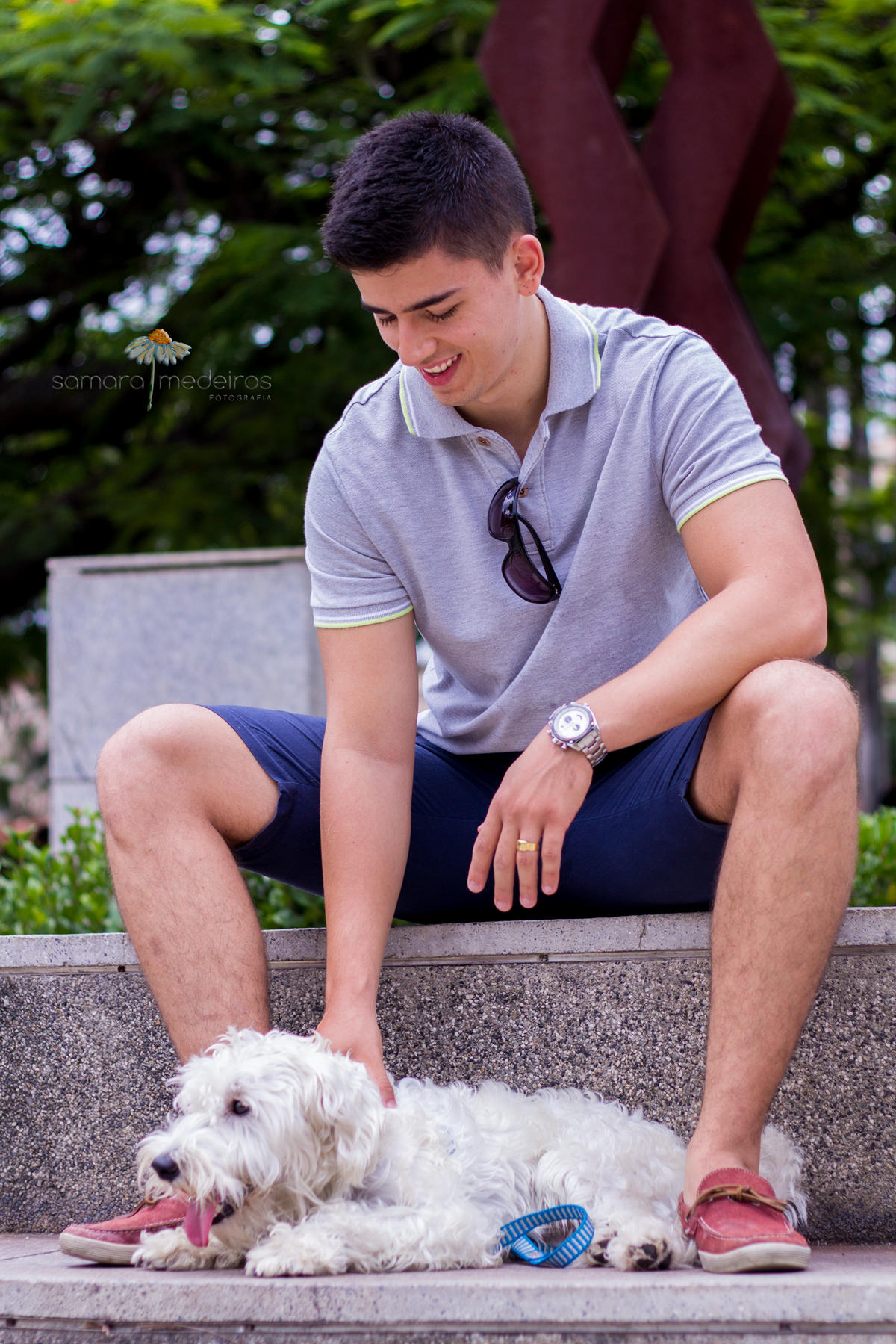 Cachorro e seu tutor sentados em uma escada em praça de Belo Horizonte, posando para fotos.