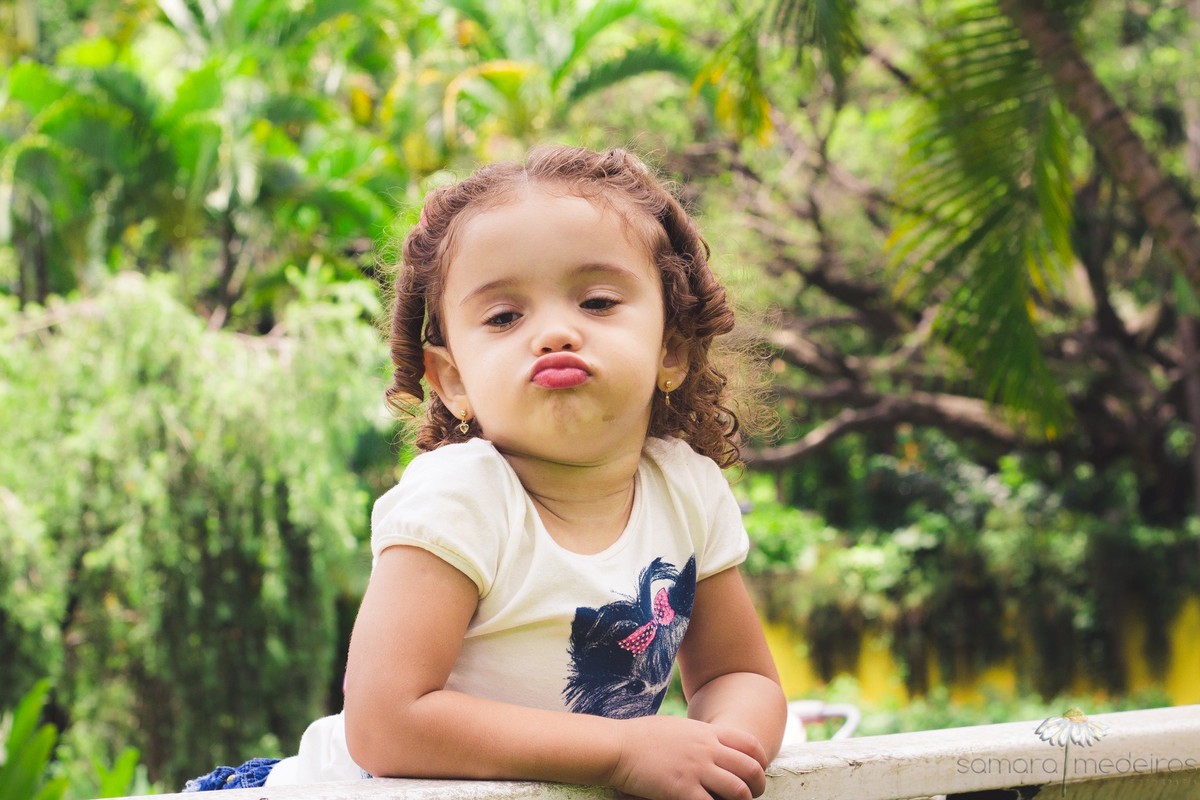 Criança fazendo careta para a foto em um ensaio infantil em parque de Belo Horizonte.
