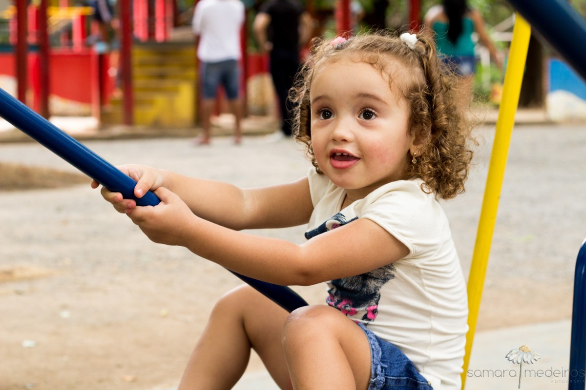 Criança brincando no parquinho infantil do parque municipal de Belo Horizonte durante um ensaio fotográfico.