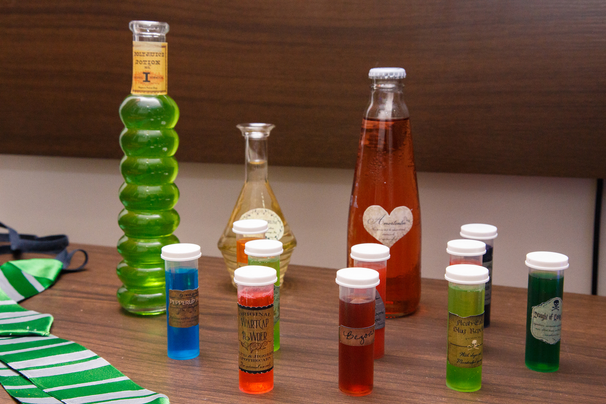 Detalhe da decoração de aniversário com tema Harry Potter, com algumas garrafas com líquidos coloridos como poções.