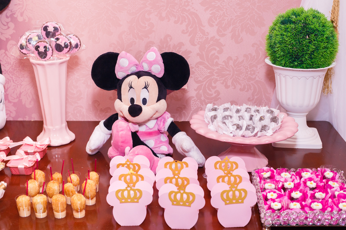 Detalhe dos docinhos e personalizados de uma festa de aniversário infantil no tema Minnie, da Disney.
