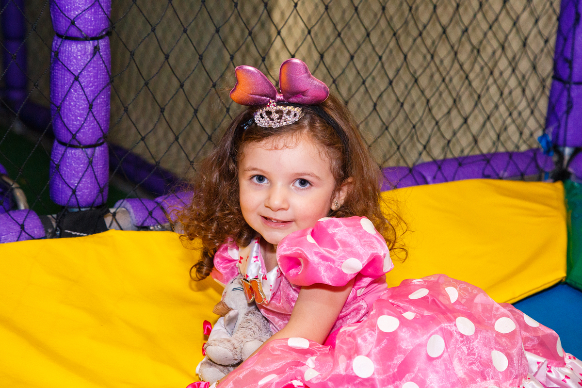 Criança sentada posando para foto dentro do pula pula após cair durante a brincadeira.