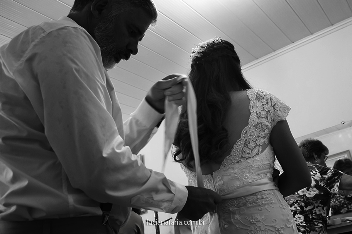 fotógrafa de casamento luciana faria em poços de caldas registra laço do vestido feito pelo pai da noiva