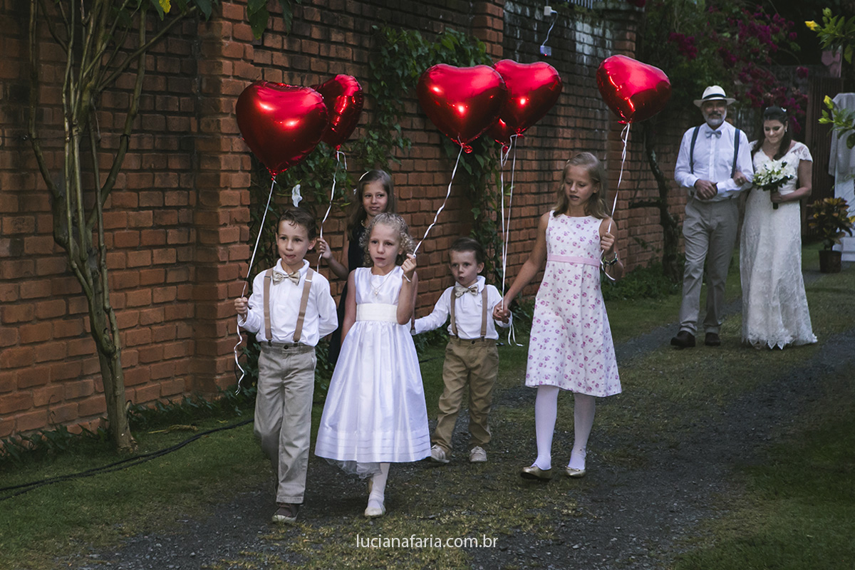 entrada da noiva com balões de coração vermelho levado pelas crianças foto feita por luciana casamentos