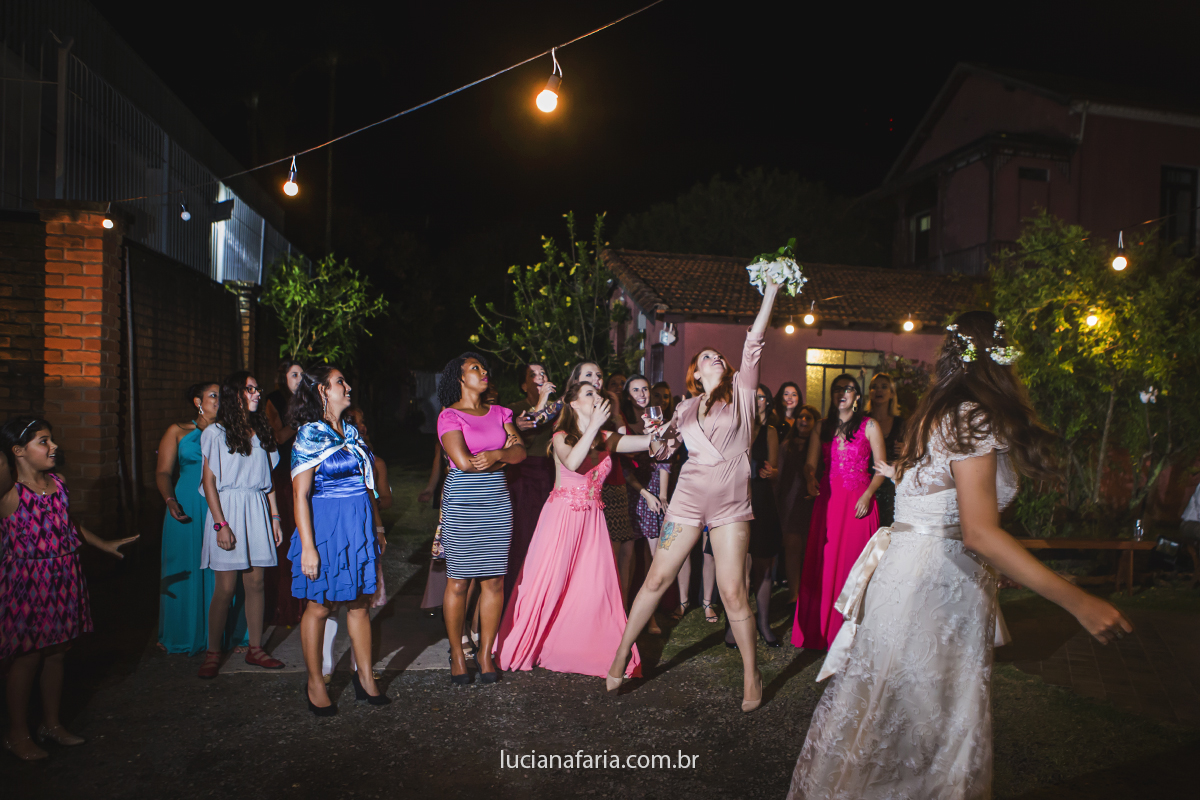 jogando buque para as amigas na festa do casamento