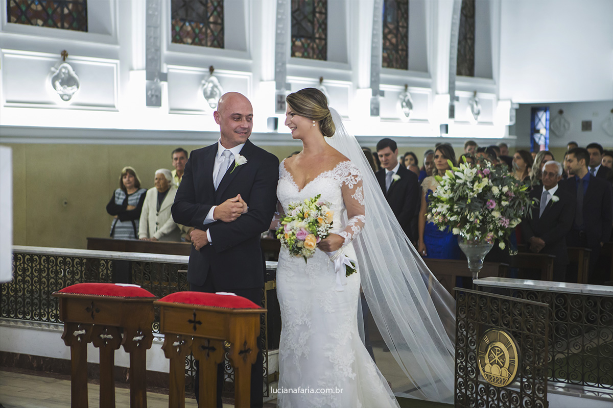 noivos no altar na cerimônia religiosa buque da noiva com flores amarelas veu e grinalda registrado pela fotografa de casamento luciana faria