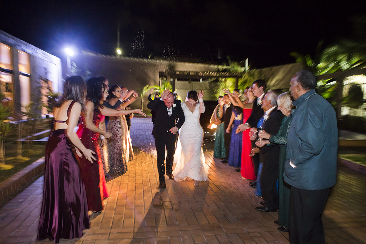 chuva de arroz sorte no casamento entrada dos noivos no salão padrinhos e madrinhas do casal no corredor registrados pela fotógrafa de casamento em poços de caldas