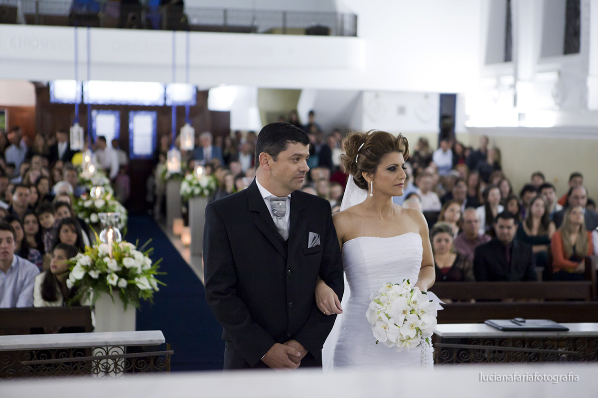 noivos no altar, terno, vestido, convidados, decoração, flores, tapete azul, leitura, músicos, evangelho