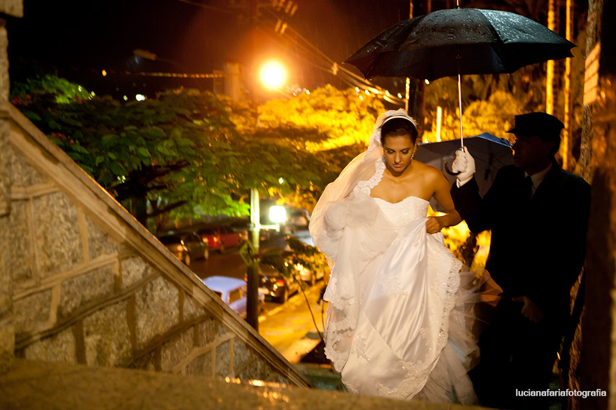 noiva, grande dia, casamento com chuva, carro da noiva, noiva no carro, casando, indo pra igreja, carro azul, motorista, oração da noiva, carro molhado, gotas de chuva, porta da igreja cerimonial, buquê, escadaria, guarda chuva