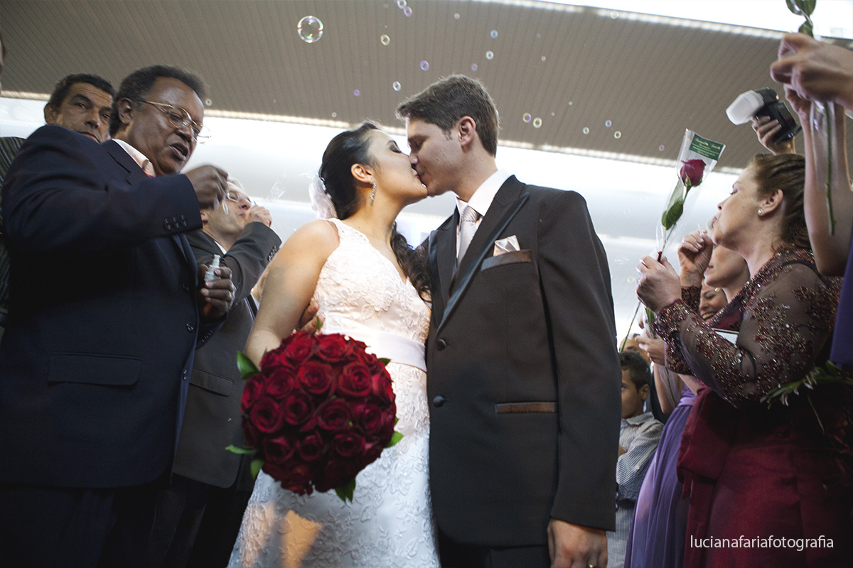 buquê vermelho, rosas, bolinhas de sabão, saída dos noivos, porta da igreja,amor, noivo, casei, noiva, decoração, chuva no casamento, cerimônia, religioso, beijo, enfim casados