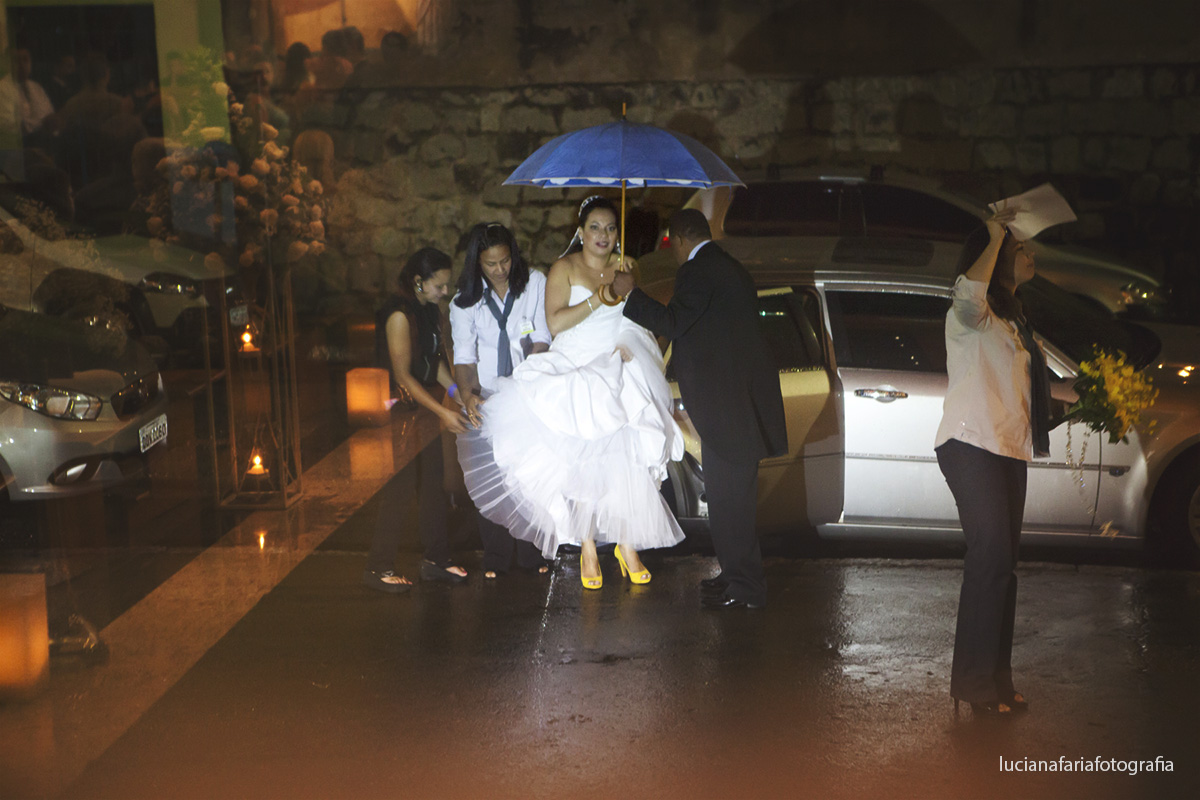 noiva saindo do carro, chuva, guarda chuva, sapato amarelo, igreja, noiva, porta da igreja, noiva na porta, noiva no carro, carro, luz, amarela, igreja de vidro, casamento, cerimonial, cerimônia, religioso, católico, ansiedade, emoç&at