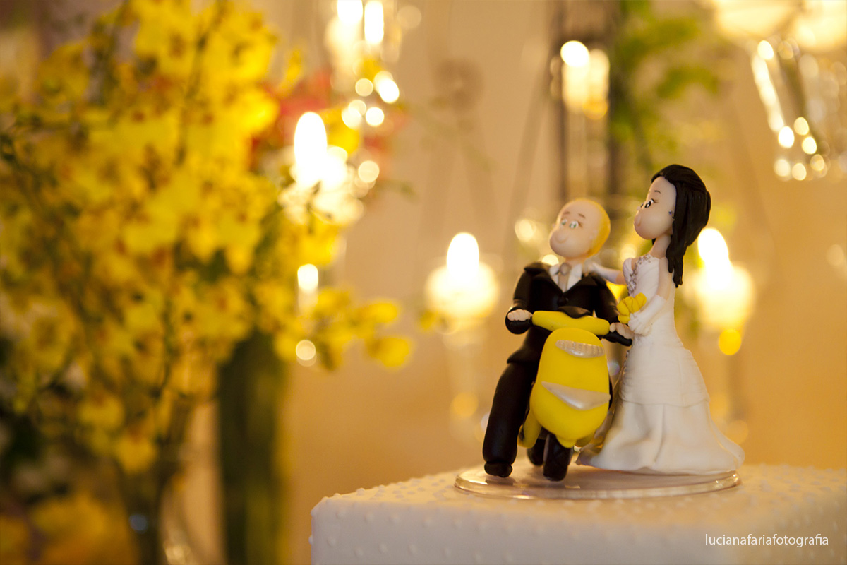 recepção, mesa do bolo, bolo, topo, noivinhos, lambreta, orquídeas, amarelas, velas, flores, fotos dos noivos, noiva, casamento, cerimonial