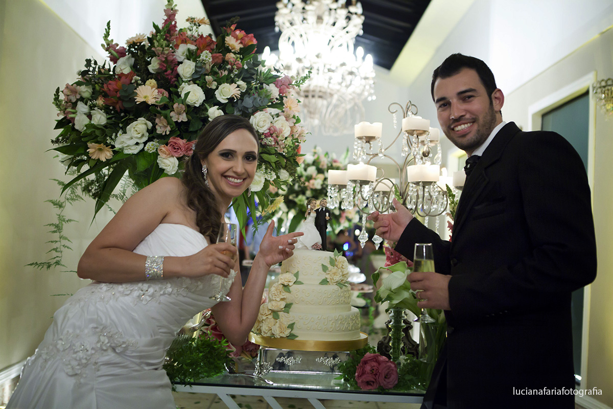 noivos, brinde, corte do bolo, decoração, casamento, flores, folhas, mesa do bolo, bolo de noiva, noivinhos, caricatura, lustre no salão, buffet, festa, recepção, casados, iluminação, salão, cerimoni