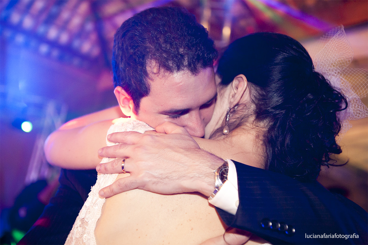 noivos se abraçam dançando a valsa do casamento com musica do casal no salão de festas lafarme de poços de caldas fotógrafa de casamento